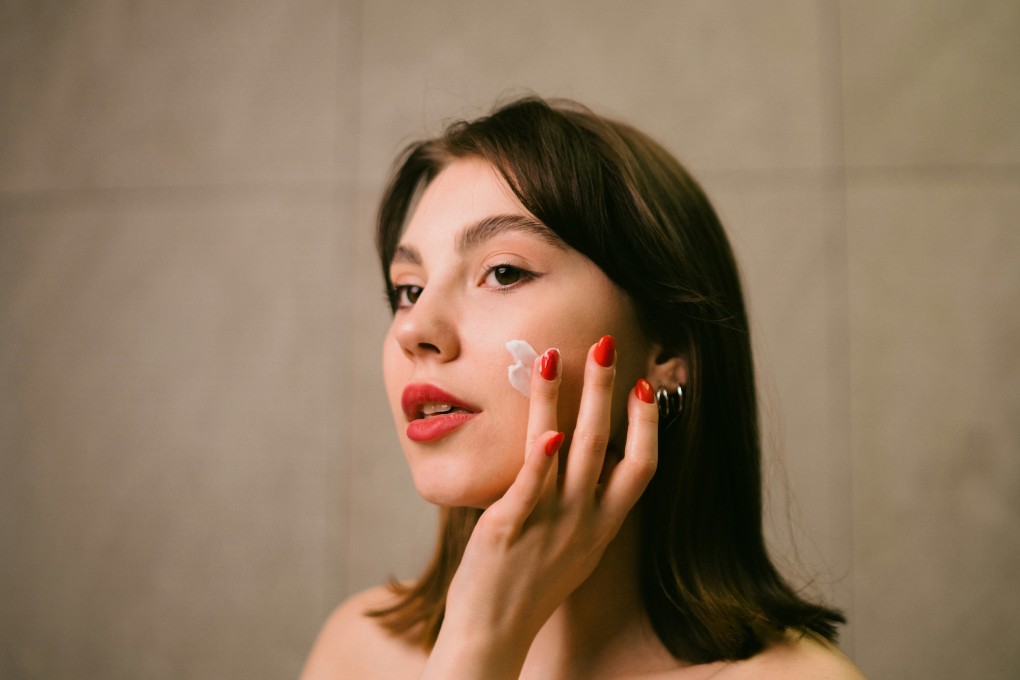A young woman applying at-home skincare after visiting SPRY Skin & Wellness for hyperpigmentation treatment in Waterloo.