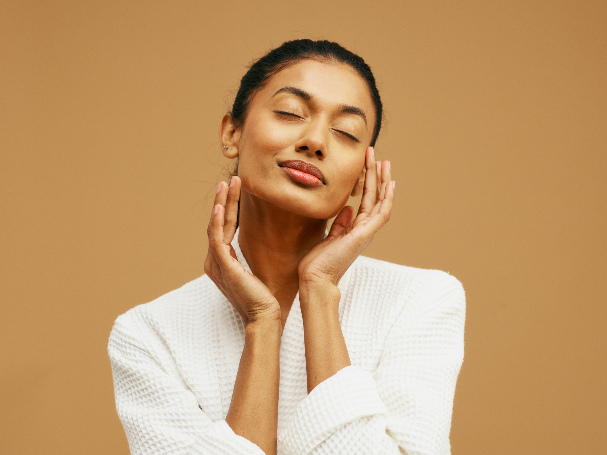 A woman in a cozy robe enjoys her clear skin after treatment with intense pulsed light near Cedar Falls.